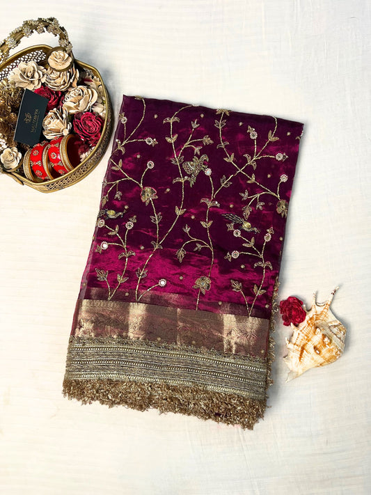"Hand-embroidered Wine Banarasi tissue silk saree with intricate floral and bird motifs in gold zari and sequin work, finished with a delicate gold zari woven border."