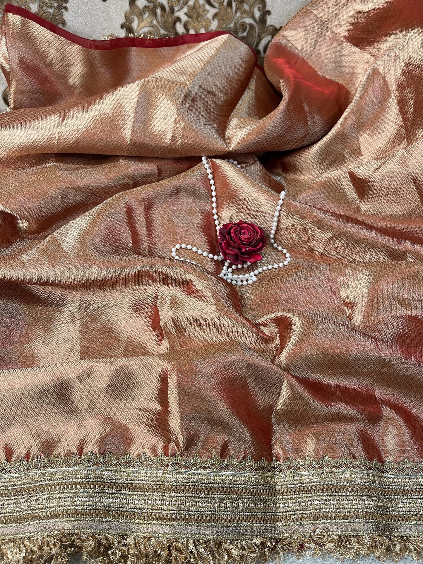 "Hand-embroidered Wine Banarasi tissue silk saree with intricate floral and bird motifs in gold zari and sequin work, finished with a delicate gold zari woven border."