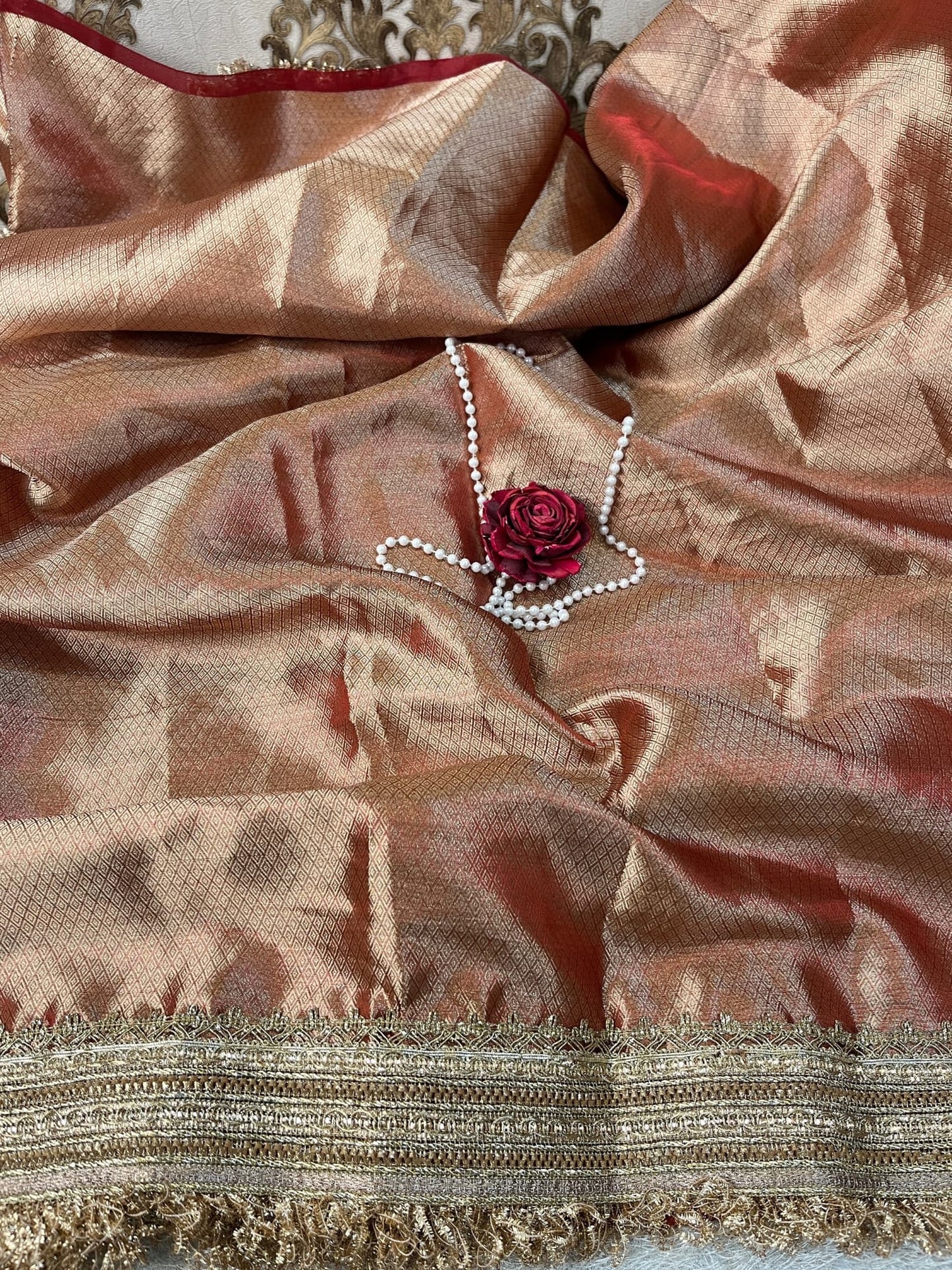 "Red 100% pure Banarasi tissue silk saree featuring a beautifully embroidered white swan motif with floral detailing in silver and red. Adorned with scattered buti work, a richly woven zari pallu, and a gota patti lace border. Ideal for weddings, receptions, and festive occasions. Comes with an unstitched brocade blouse."