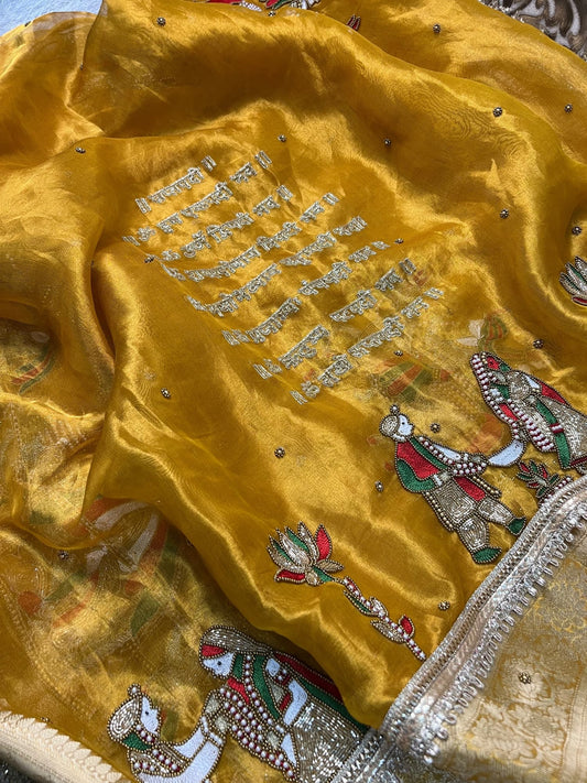“Mustard Yellow Saat Vachan Banarasi silk saree with wedding motifs and festive embroidery”