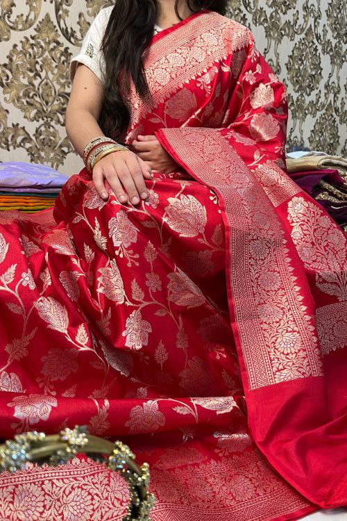 Handwoven Red Katan Silk Saree with floral jaal pattern and intricate sona rupa zari border and anchal, paired with a plain red blouse piece featuring floral zari border for sleeves – made in Banaras.