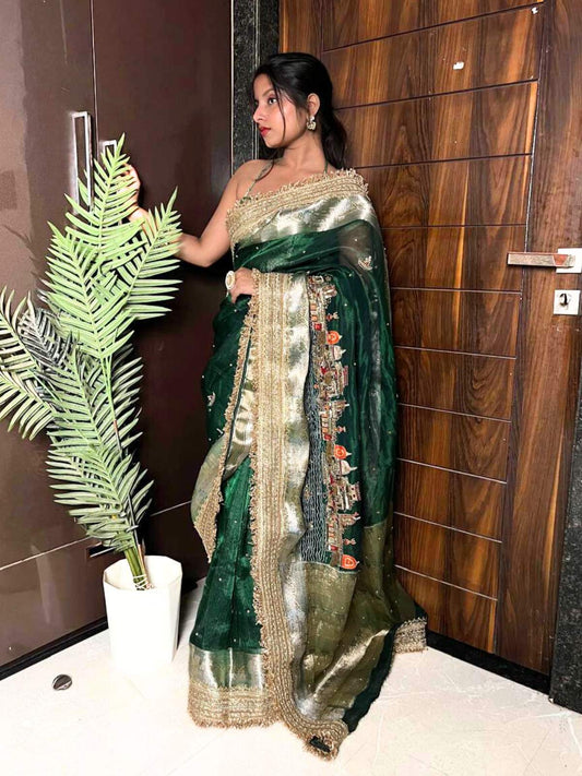 Emerald green Banarasi saree with hand embroidery of Varanasi ghats, boats, temples, and river scenes.