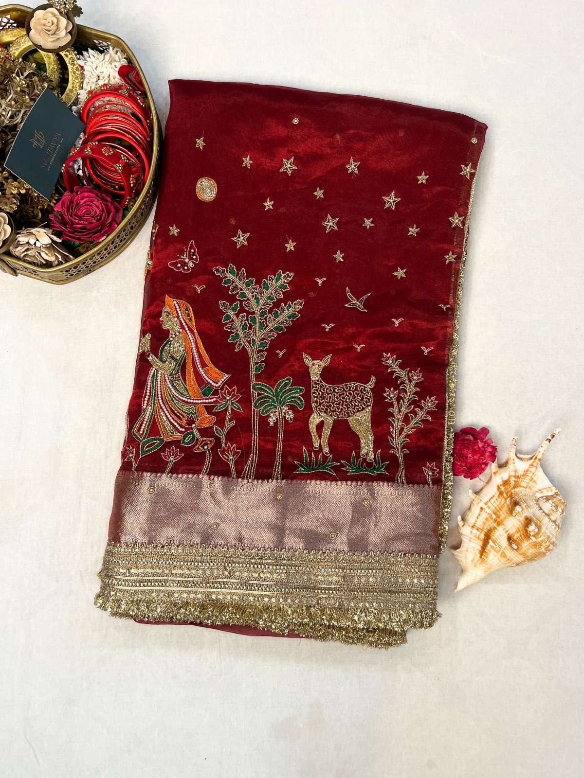Manatavya Banaras maroon Radha Krishna tissue silk saree with handwoven deity motifs, gold zari border, and elegant festive drape