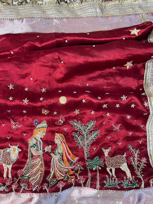 Manatavya Banaras maroon Radha Krishna tissue silk saree with handwoven deity motifs, gold zari border, and elegant festive drape
