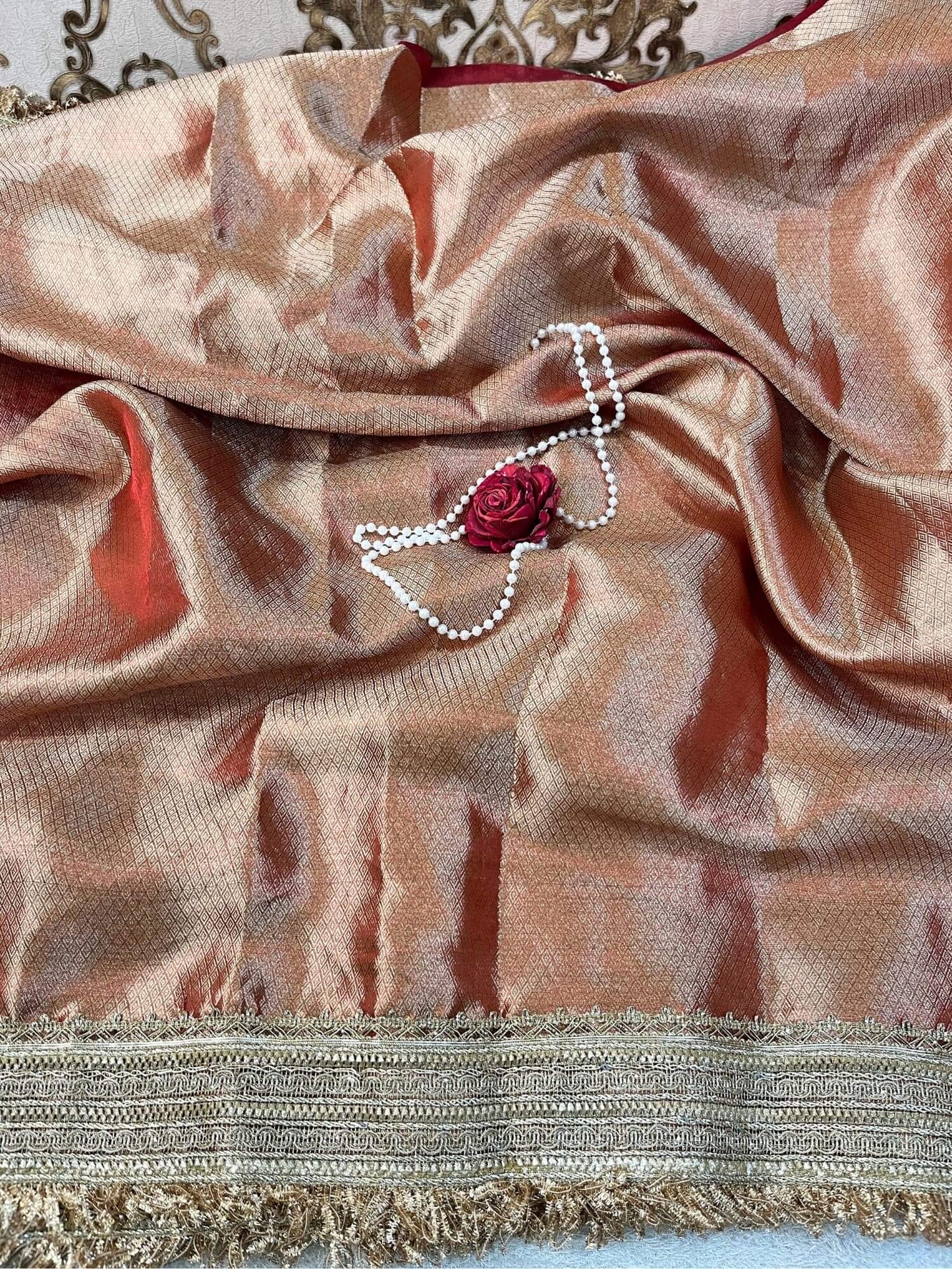 "Hand-embroidered red Banarasi tissue silk saree with intricate floral and bird motifs in gold zari and sequin work, finished with a delicate gold zari woven border."