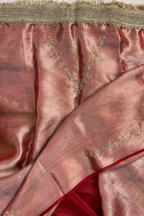 Red hand embroidered tissue silk saree with diagonal stripes and floral buti, paired with brocade blouse with hand embroidery on neck and sleeves.