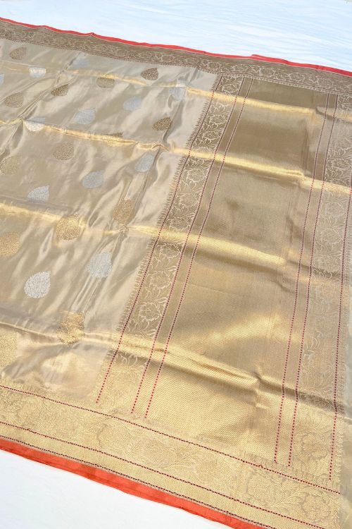 Beige Kora Tissue Pure Silk Saree with golden and silver zari butas and red contrast selvedge border