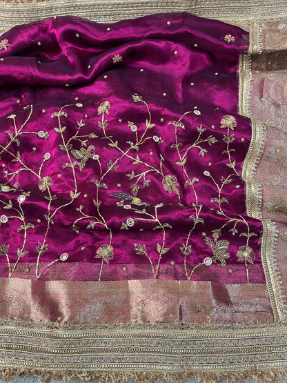 "Hand-embroidered Wine Banarasi tissue silk saree with intricate floral and bird motifs in gold zari and sequin work, finished with a delicate gold zari woven border."