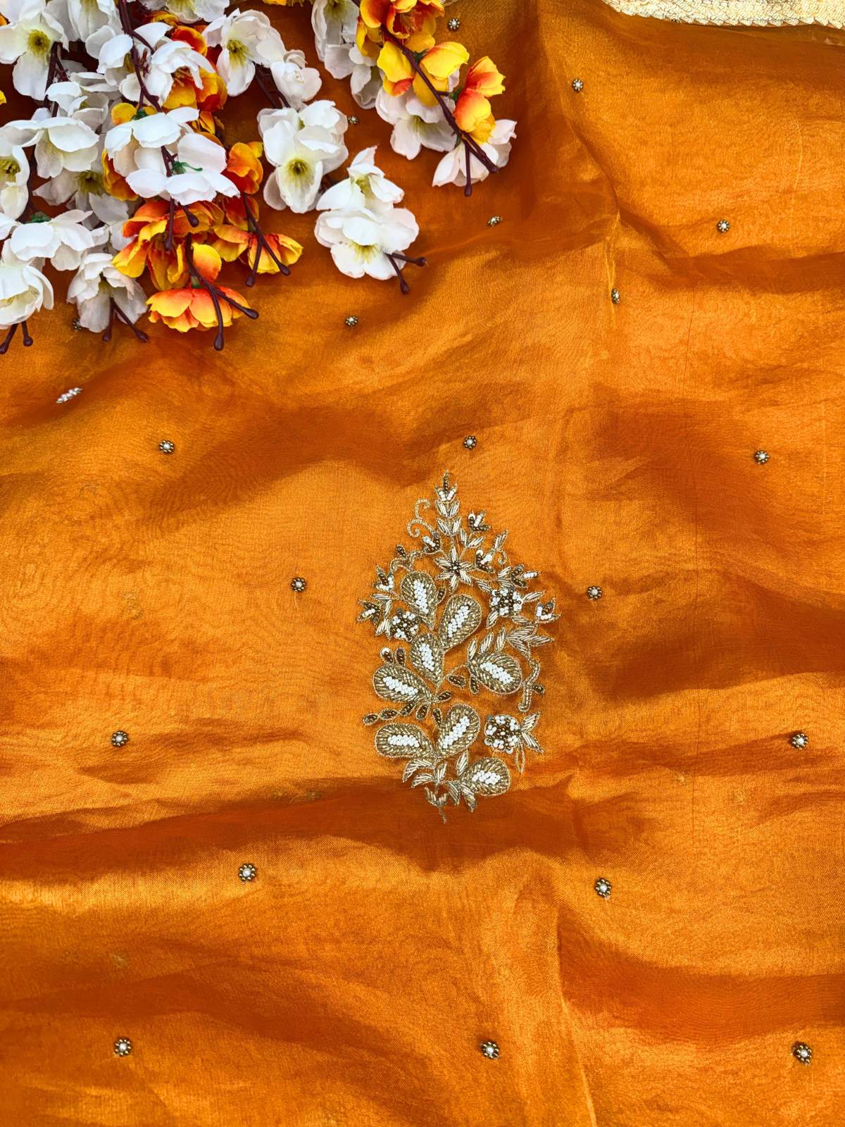 Orange fabric with silver embroidery and floral decorations Mantavya Banaras