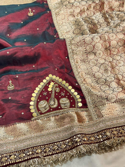 Close-up of a maroon fabric with gold embroidery on a white background