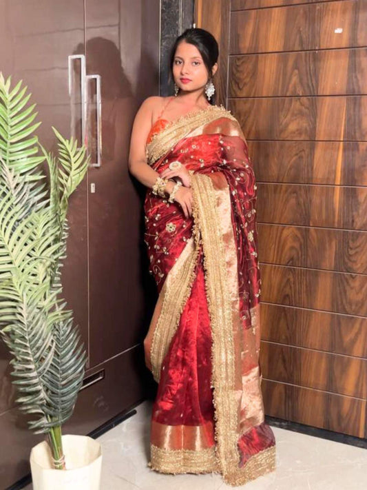 "Hand-embroidered red Banarasi tissue silk saree with intricate floral and bird motifs in gold zari and sequin work, finished with a delicate gold zari woven border."