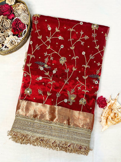 "Hand-embroidered red Banarasi tissue silk saree with intricate floral and bird motifs in gold zari and sequin work, finished with a delicate gold zari woven border."