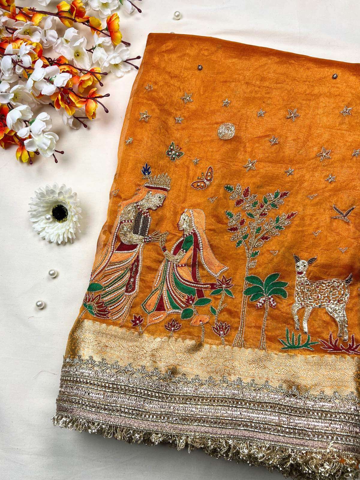 Orange Radha Krishna Banarasi silk saree featuring divine traditional artwork
