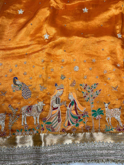 Orange Radha Krishna Banarasi silk saree featuring divine traditional artwork