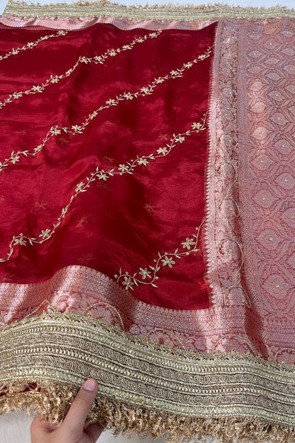 Red hand embroidered tissue silk saree with diagonal stripes and floral buti, paired with brocade blouse with hand embroidery on neck and sleeves.
