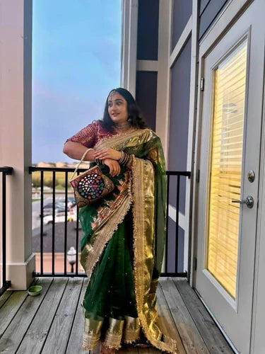 Emerald green Banarasi saree with hand embroidery of Varanasi ghats, boats, temples, and river scenes.