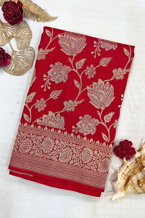 Handwoven Red Katan Silk Saree with floral jaal pattern and intricate sona rupa zari border and anchal, paired with a plain red blouse piece featuring floral zari border for sleeves – made in Banaras.