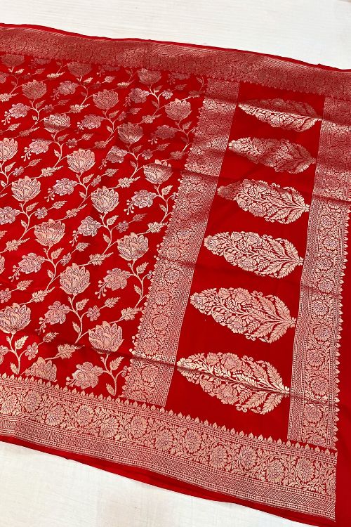 Handwoven Red Katan Silk Saree with floral jaal pattern and intricate sona rupa zari border and anchal, paired with a plain red blouse piece featuring floral zari border for sleeves – made in Banaras.