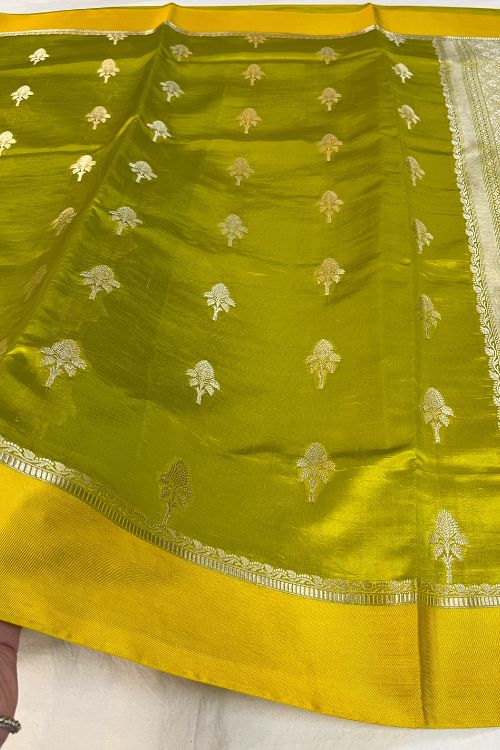 Green Raw Mango Silk Saree with satin border, buti motifs, zari aachal, and unstitched brocade blouse – handcrafted Banarasi silk saree.