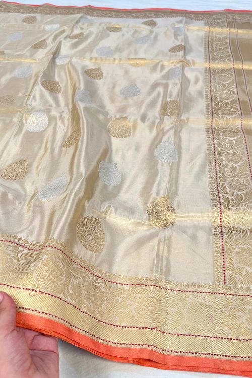 Beige Kora Tissue Pure Silk Saree with golden and silver zari butas and red contrast selvedge border