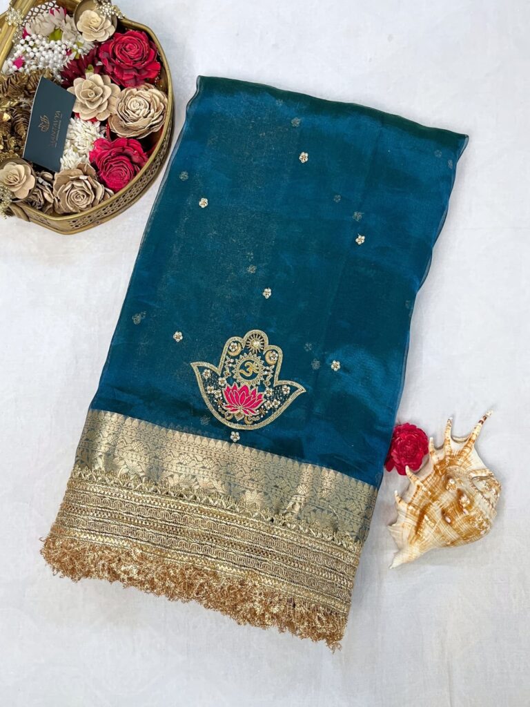 Blue Tissue Silk Saree with hand-embroidered Nazar motif featuring Om, lotus, floral, and moon designs in zari and threadwork